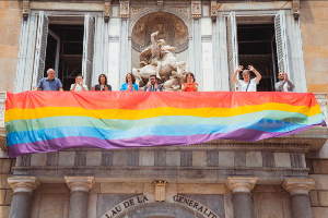 Desplegament de la bandera LGTBI+ a la balconada principal del Palau de la Generalitat